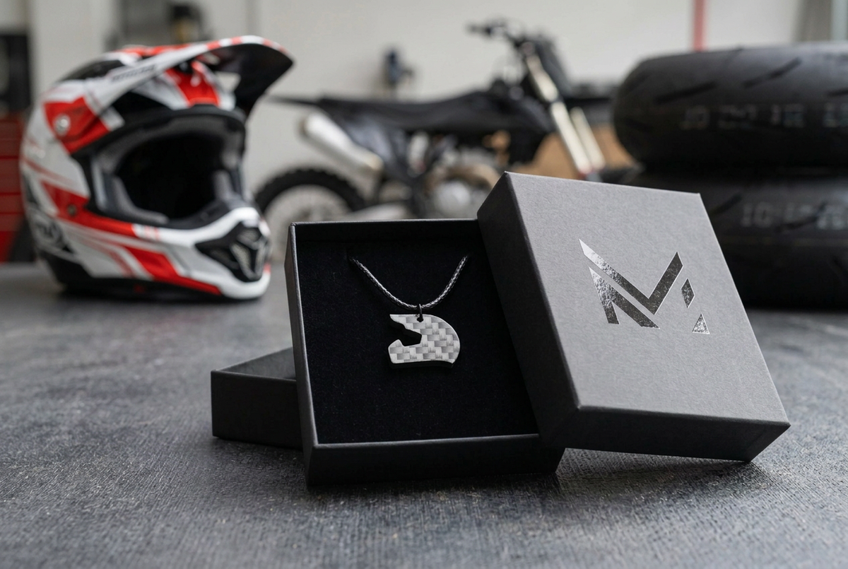 Collana Casco Moto nella scatolina M luxurys con casco e moto da cross sullo sfondo