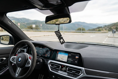 Ciondolo M3 appeso allo specchietto nell’abitacolo BMW M3, visto dal sedile passeggero